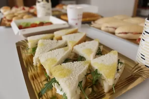 Mini sandwich artesano relleno de recula y queso de cabra troceado y en bandeja de catering