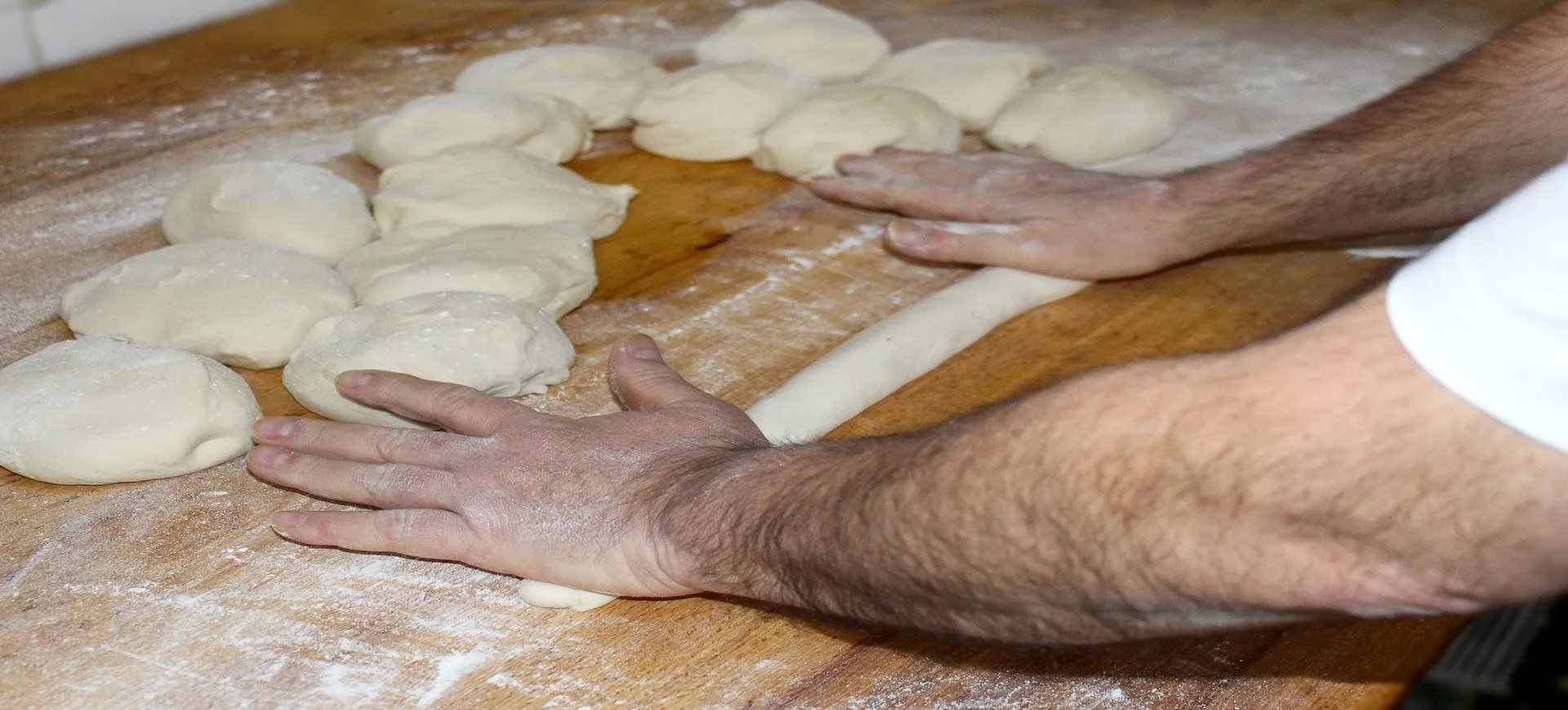 Panadero artesano amasando y dando forma a una barra de pan