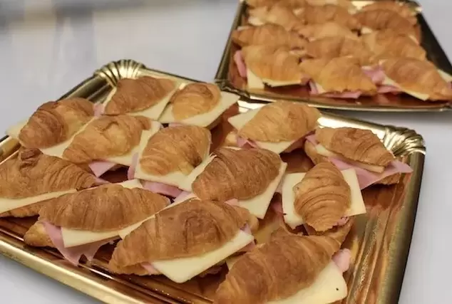 Mini croissants artesanos rellenos de jamón york y queso y presentados en bandejas